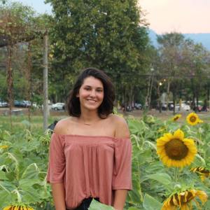 Emily standing in a field of sunflowers